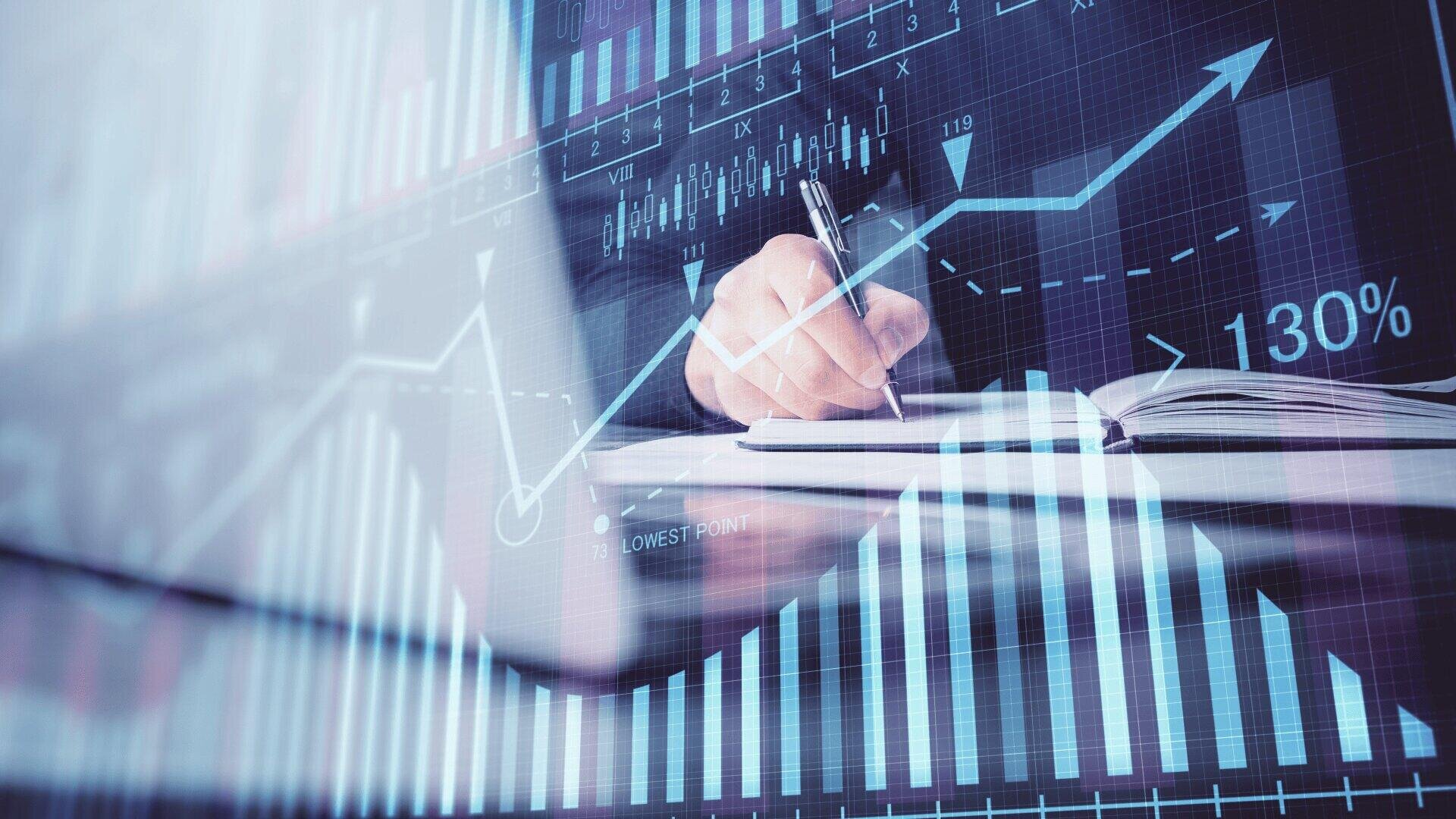 Eine Person schreibt in ein Notizbuch, in das Finanzdiagramme, Balkendiagramme und Datenvisualisierungen digital eingeblendet sind, die Finanzanalyse und Unternehmensplanung symbolisieren.