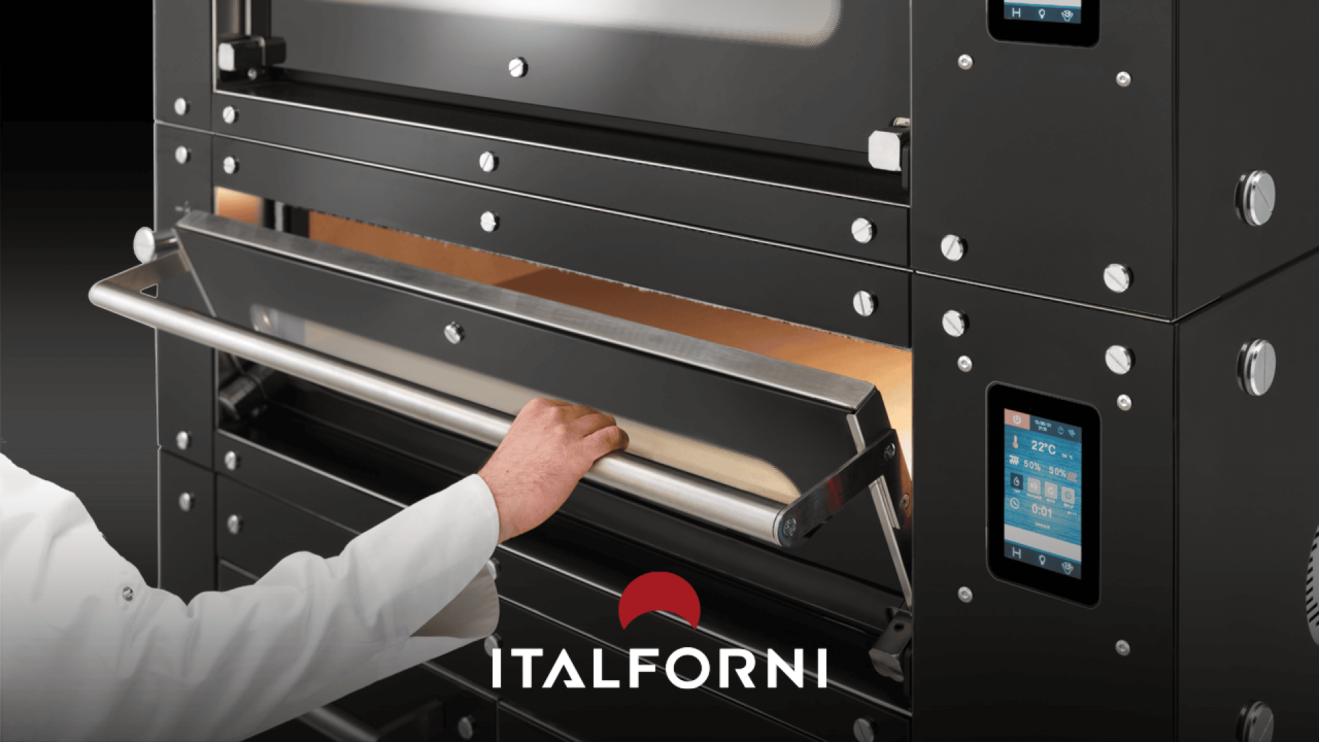 Eine Person in einem weißen Kittel öffnet die Edelstahltür eines schwarzen Italforni-Pizzaofens, an dessen Seite Bedienfelder und Digitalanzeigen zu sehen sind. Das Italforni-Logo ist am unteren Rand eingeblendet.