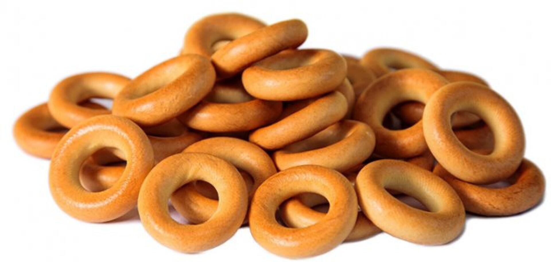 A pile of round, golden-brown bagel-shaped dry bread rings, known as sushki, on a white background.