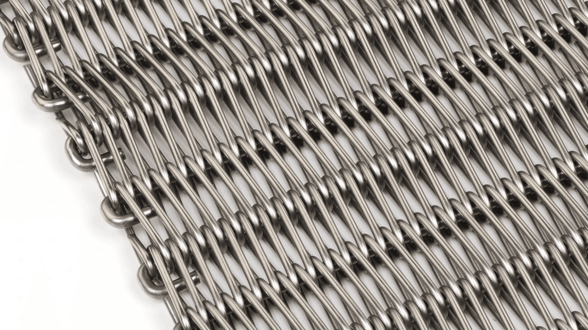 Nahaufnahme eines Förderbandes aus Metalldrahtgeflecht mit ineinander verwobenen, parallelen Drähten, die ein flexibles, gitterartiges Muster auf weißem Hintergrund bilden.