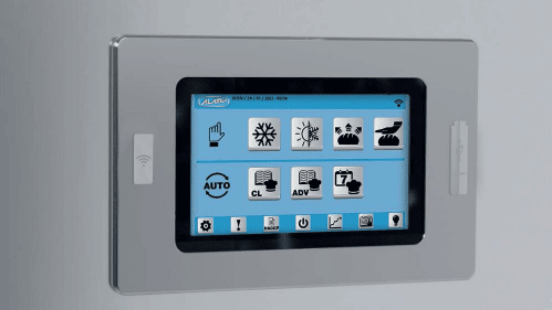 Ein Touchscreen-Bedienfeld mit Symbolen für Einstellungen wie Beleuchtung, Klima, Zeitpläne und Automatisierung ist an einer grauen Wand angebracht. Das Display zeigt verschiedene Optionen mit Symbolen und Beschriftungen auf einer blauen Oberfläche an.