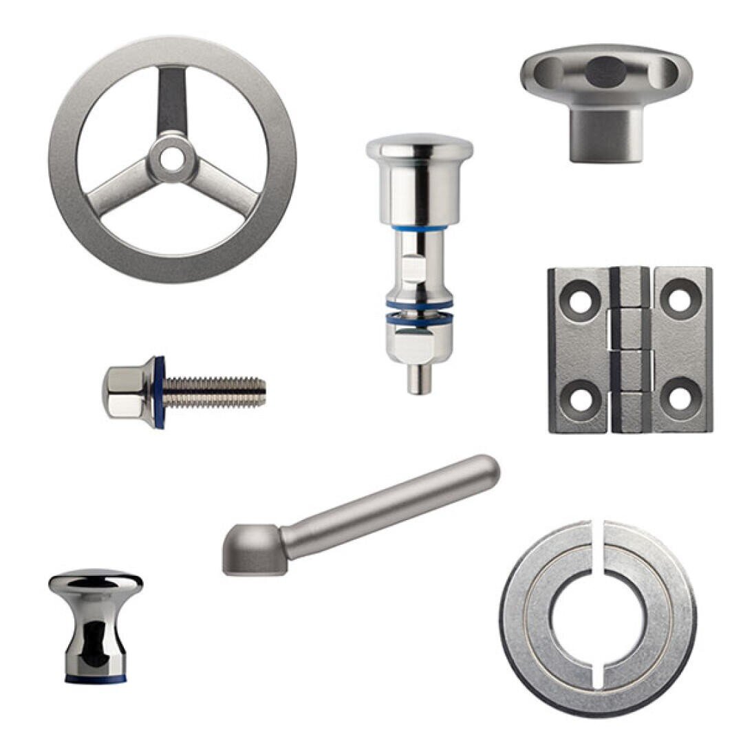 Assorted stainless steel industrial machine parts, including wheels, a hinge, a bolt, knobs, a lever, and a cylindrical component, displayed on a white background.