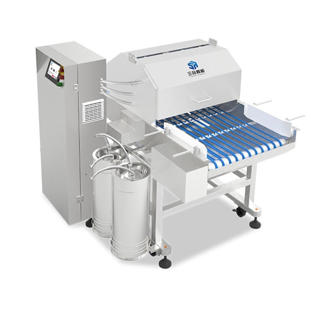 A stainless steel industrial machine with blue conveyor belts, two large cylindrical metal containers, a control panel, and a box-like upper unit featuring a blue logo, used for food or material processing.