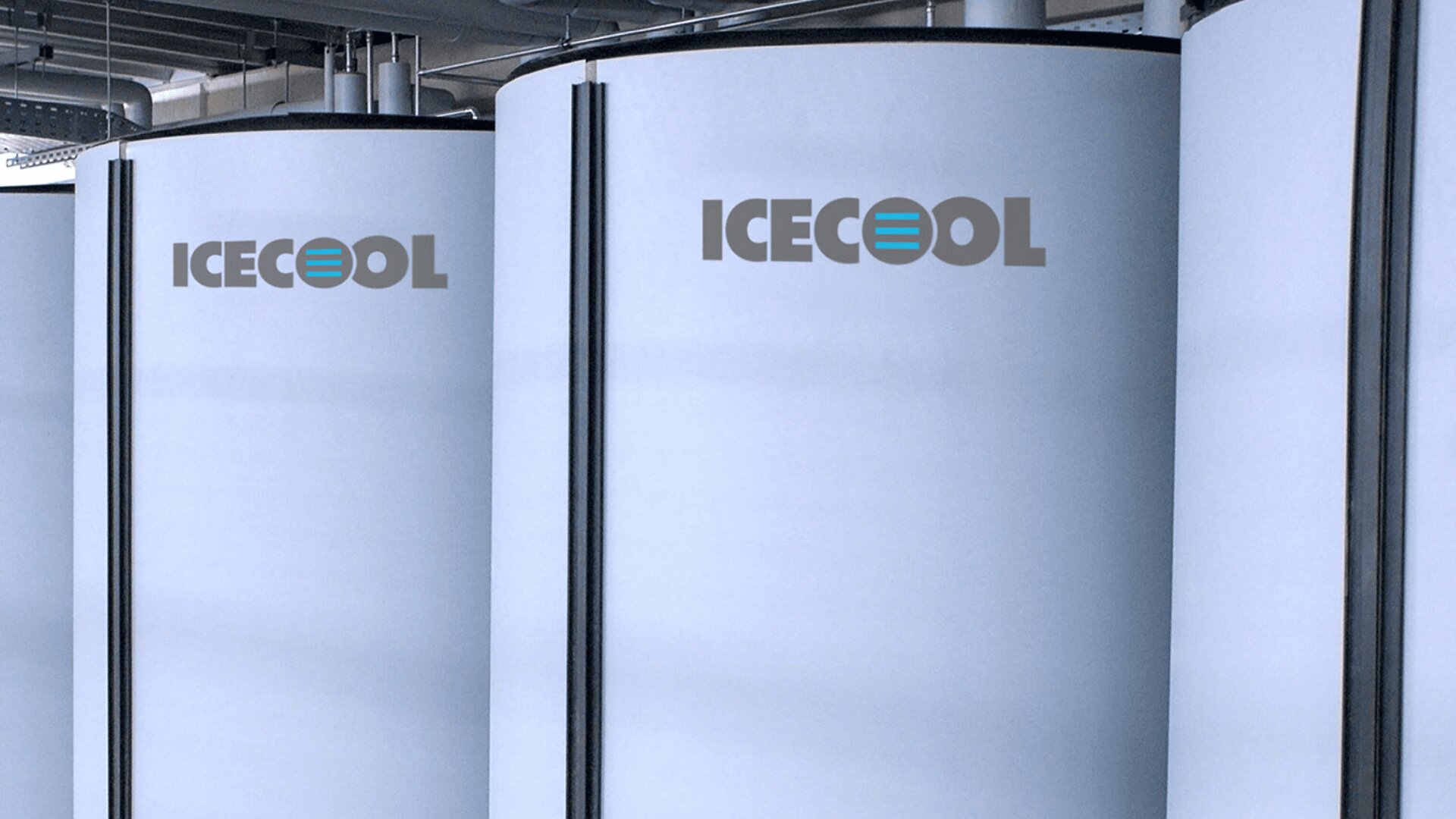 Large cylindrical tanks labeled ICECOOL are lined up indoors, featuring a modern, industrial setting with visible pipes and overhead structures.
