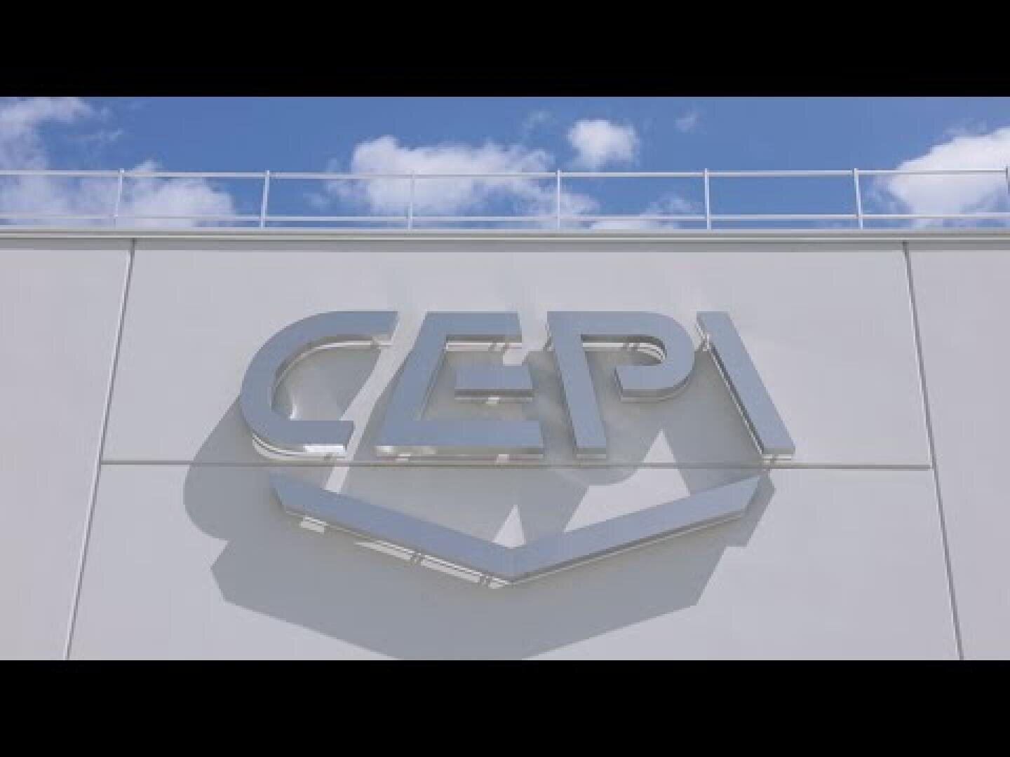 A large silver sign with the inscription CEPI is attached to a white building façade, with blue sky and clouds in the background.