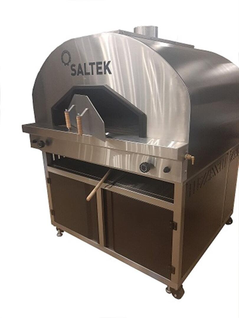 Ein großer Pizzaofen auf Rädern aus rostfreiem Stahl und schwarzer Farbe mit der Aufschrift SALTEK, an dessen Vorderseite zwei Pizzageräte mit Holzgriff hängen.