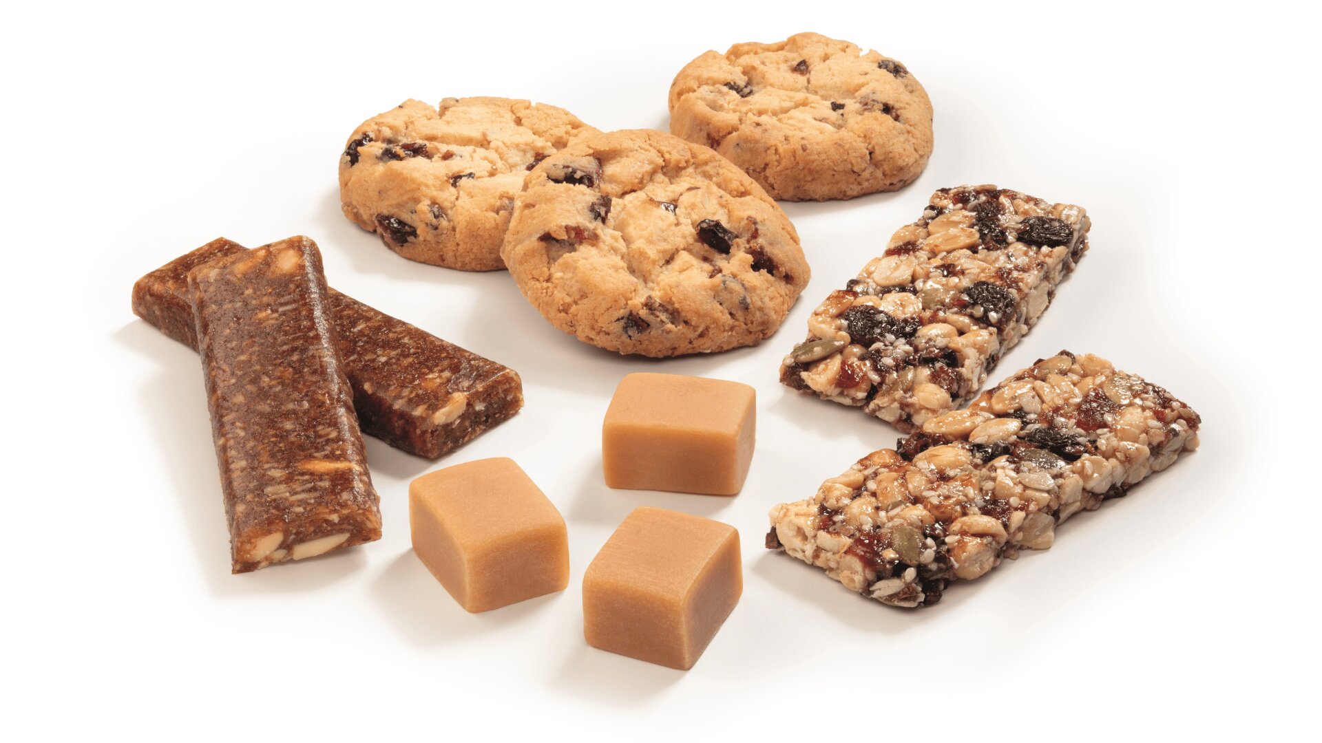 Eine Auswahl an Snacks auf einer weißen Fläche, darunter drei zähe Müsliriegel mit Nüssen und Trockenfrüchten, vier runde Kekse mit Schokoladenstückchen oder Früchten, drei Karamellwürfel und zwei rechteckige braune Frucht- und Nussriegel.