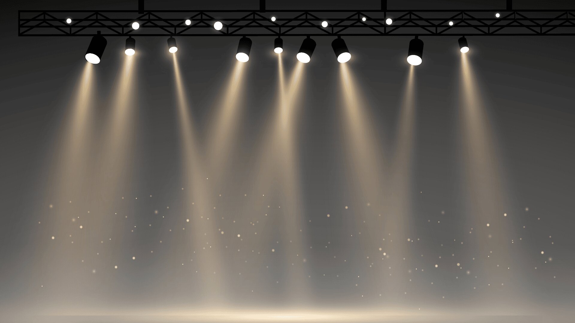 A row of spotlights on a stage shines bright beams of light downward, illuminating floating dust or glitter in the air against a dark background.