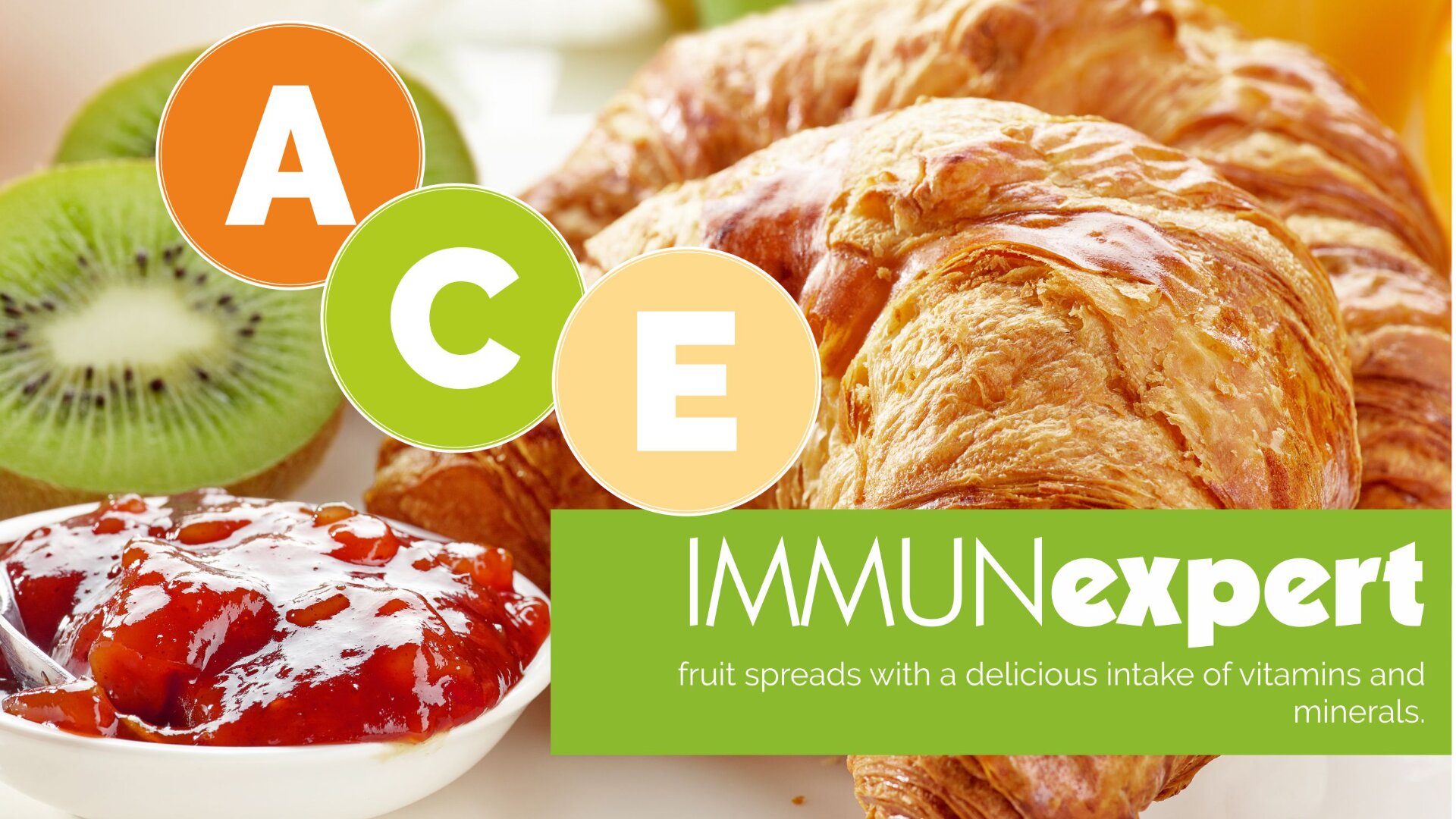 A close-up of croissants, sliced kiwis, and strawberry jam with circles labeled A, C, and E. The text reads: IMmunexpert: fruit spreads with a delicious intake of vitamins and minerals.