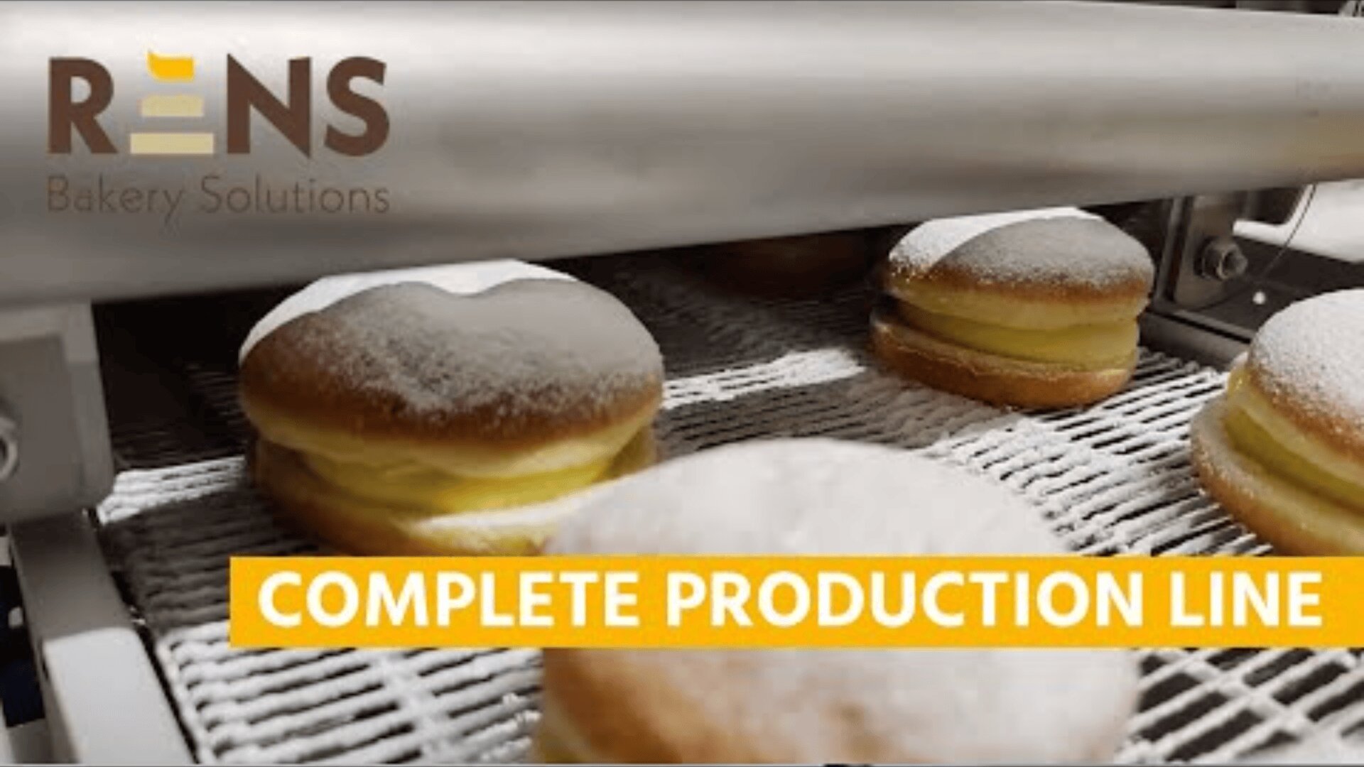 Puderzucker-Donuts werden in einer Bäckerei-Produktionslinie auf einem Förderband transportiert. Auf dem Bild sind die Texte „RENS Bakery Solutions“ und „COMPLETE PRODUCTION LINE“ zu sehen.