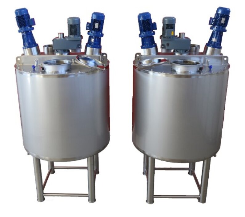 Two identical stainless steel industrial mixing tanks with blue electric motors and control units mounted on top, each standing on four-legged metal frames.